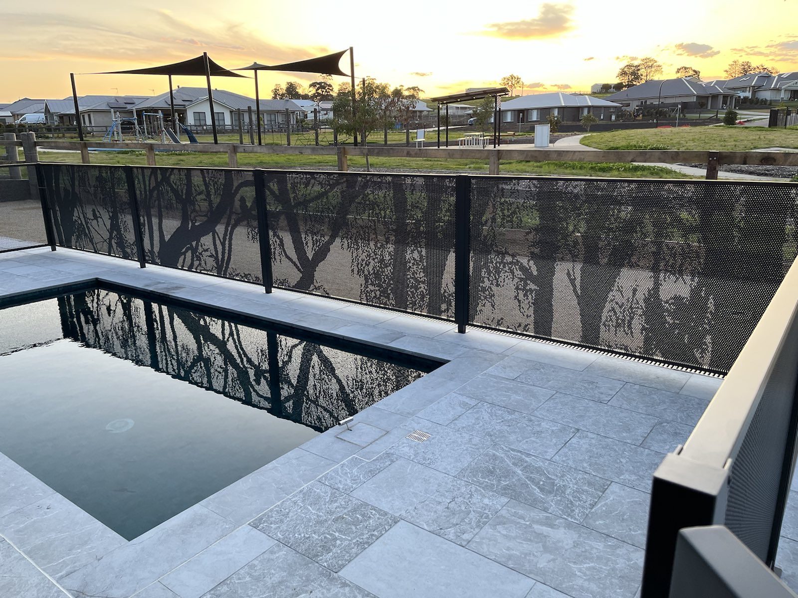 Australiana design perforated pool fencing in Textured Black around a Newcastle backyard pool